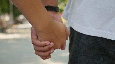 Kadın ve erkek ellerini birbirine aşık iki el birbirine sıkıca tutarak slo-mo Closeup bir sokakta bir işareti olarak tutmak. Mutlu bir çift aşık bir cadde boyunca yaz yavaş çekimde yürürken ait oldukları