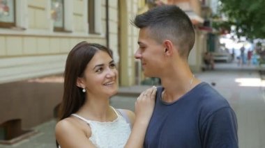 Mutlu genç çift birbirine bakarak sokakta sevgiyle birbirine tutkuyla bakarak ve neşeyle bir şehirde yavaş yaz aylarında sokak gülümseyen aşık genç bir aile portresi slo-mo içinde yaz.