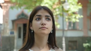 Sevimli genç kadın aroundi n bir sokak slo-mo harika görünümünde yukarı ve çevresinde bir sokak kesinti binalarda yaz slo-mo bakarak derin iri gözlü romantik bir esmer kadının tarihi evleriyle arıyor