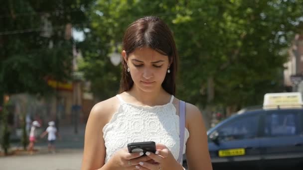 Inschrijving Brunet Meisje Surfen Het Net Haar Telefoon Een Straat — Stockvideo