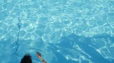 Atletik brunet adam yüzme kurbağalama yavaş hareket breastsroke uzakta temiz ışık mavi yüzme havuz açık havada yaz yavaş yüzme bir brunet delikanlı harika manzarasını transparan bir havuzda