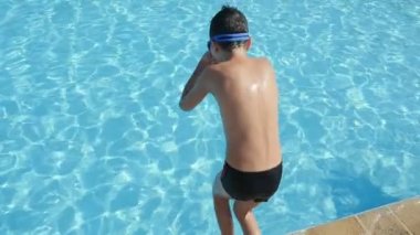 Ayak önce slo-mo arka görünümü bir yüzme havuzu kabarcıklanma sıçramalarına çok ağır çekimde neden ayak ilk insee-ile suların dalış bir on yaşındaki çocuk mavi bir su birikintisi atlama küçük çocuk yüzme gözlüğü