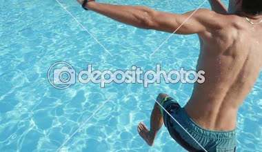 Yaz slo-mo ayak ilk yüzme havuzunda slo-mo geri yaz aylarında genç brunet biri ile ayak ilk celeste ile yüzme su birikintisi atlama şort sportif bir şekilde görünümünü atlama şortlu genç adam sular
