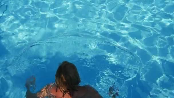 运动的金发女子游泳蛙泳在一个泳池夏季在慢动作的一个愉快的金发女子在比基尼游泳蛙泳在夏天在一个波光粼粼的蓝色水域在慢动作的泳池 — 图库视频影像