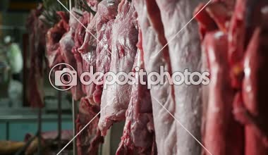 Çiğ et parçaları otomatik bir konveyör büyük gıda ambar içinde asılı bir büyük dondurucu heyecanlı closeup içinde çiğ domuz eti, Dana ve sığır eti bangling çizgileri. Domuz, sığır eti ve koyun eti.