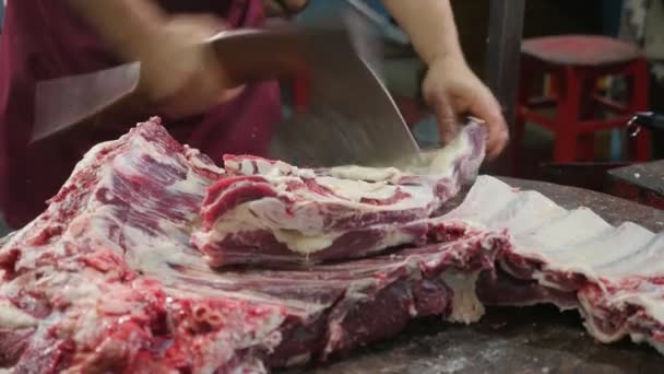 屠夫的手砍猪胴体与肋骨使用斧头迅速令人印象深刻的屠夫的手切割和砍猪肉与 Lardand 肋骨迅速在一个木桌在一个宽敞的屠宰 — 图库视频影像