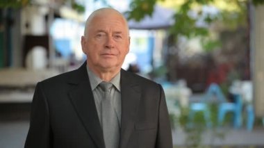 Onun kendinden emin bir komuta sizde sokak portresi sırayla onun kravat sipariş bir kafede sonbaharda koyarak bir siyah businesssuit içinde kısa saç kesimi ile hie bir iş takım elbise koyar içinde saygın eski adam