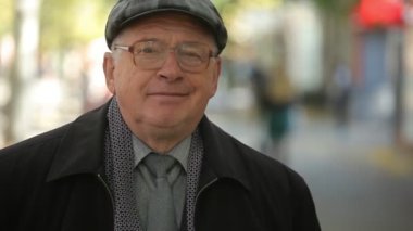 Mutlu komuta sizde eyelasses ve bir kap ayakta bir sokakta bir düz kapak ve ayakta ve güneşli bir sonbahar aylarında yoğun bir cadde neşeli gülümseyen yün palto üst düzey bir adamın sonbahar olumlu portre