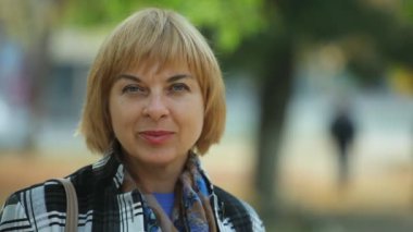 Gülümseyen bir parkta neşeli sonbahar harika bokeh görünümü şık bir sarışın kadının yeşil bir parkta sonbaharda gülümseyen bir siyah ve beyaz ekose ceket giymiş bir bob saç modeli ile moda romantik sarışın kadın giyinmiş 