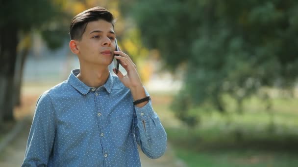 Reliant Jovem Morena Homem Falando Seu Smartphone Parque Verde Outono — Vídeo de Stock