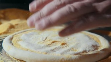 Erkek el basın ve hamur pizza için yaymak ve topsy-turvy slo-mo Amazing makro atış taze hamur pizza için tuşuna basıp bir mutfak slo-mo ufalanan kraker üzerinde yerleştirerek süre teslim şef el açın