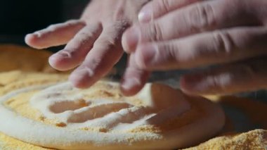 Erkek el bir hamur topu bir düzleştirilmiş pizza taban üzerinde koymak ve slo-mo özgün makro çekim net kraker ile kaplı ve üzerine ağır çekimde basarak düzleştirilmiş pizza altlığı bir hamur topu koyarak Şef eller üzerinde basın