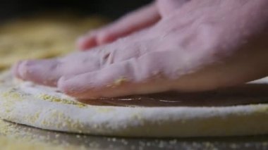 Ufalanan kraker slo-mo sanatsal makro çekim yayılan ve taze hamur pizza yavaş çekimde bir mutfakta sarı kraker metalik bir tablo için iplik Şef eller erkek eller taze hamur pizza için dönen yerleştirilen