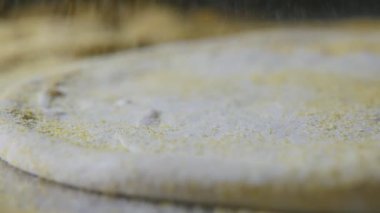 Erkek parmak eleme kraker taze pizza hamuru ve çekimde iplik üzerinde heyecanlı makro çekim Şef taze pizza hamuru ve ağır çekimde metalik bir tablo üzerinde dönen dökülen sarı kraker parmak
