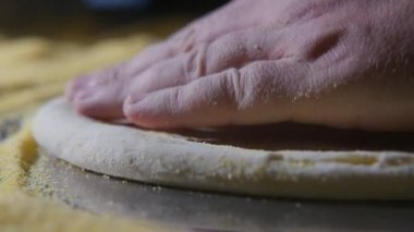Erkek el taze hamur ufalanan tahıl slo-mo yayılan ve taze hamur pizza sarı tahıl ile metalik bir tabloda basarak Şef eller etkileyici makro çekim ve yavaş bir mutfakta yerleştirilen pizza için tuşuna basın