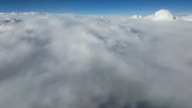 Hava tepelik, sağlam ve beyaz bulutlar bir uçak penceresinden kaba ve düzensiz beyaz bulutlar bir uçak penceresinden Arty görünümünü güneşli yaz aylarında yaz. Parıldayan celeste gökyüzü üzerindedir.