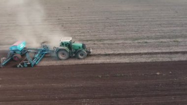Küçük bir traktör geniş bir pulluk güneşli bir sonbahar Amazing kuş bakışı kulak düzinelerce ile geniş bir pulluk çizim ve sonbaharda bir tarımsal alan yariklar hızlı modern bir traktörün çekerek hava atış