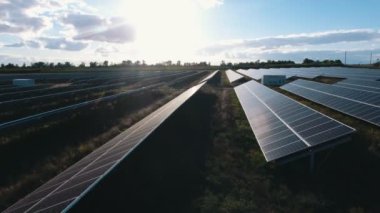 Bir güneş güç istasyonu ile yaz aylarında günbatımında Günbatımı muhteşem kuş bakışı parlak güneş güç istasyonunun düşük uçan uçak düz paneller ve mavi gökyüzü ile gelen parlayan, uzun panellerinde bu hava atış