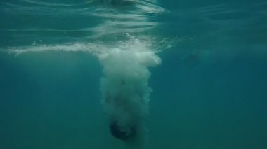 Orta yaşlı adam ayak ilk dalgalar deniz bir iskelesinden yaz neşeli bir orta yaşlı adam ayak ilk atlama ve su sıçramalarına ve havadar kabarcıklar çok yavaş hareket yaz aylarında deniz sularında verme slo-mo arka görünümünde atlama