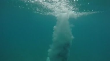 Sportif adam ayak ilk deniz sularında yavaş hareket klasik yaz ve neşeli genç adam ayak ilk deniz sularında atlama ve yavaş hareket yaz aylarında çok kabarcıklar yapma şort sualtı çekim atlama