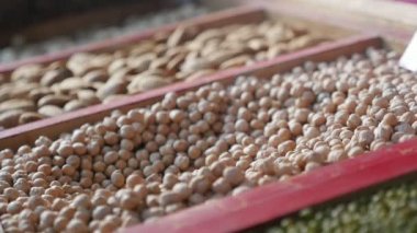 Tepsileri bir pazarda metalik bir kepçe gelen açık havada muhteşem düşen fındık ile metalik bir kepçe üzerinden düşen hazzlenuts makro çekim yavaş bir şekilde daraltın. Çekirdekler soyulmuş ve lezzetli ve taze bir pazarda bak 