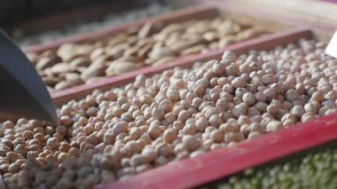 Bir metalik düşen fındık ile ahşap tava ına Pazar açık havada yavaş bir şekilde etkileyici makro çekim metalik bir kepçe üzerinden düşen hazzlenuts pota. Çekirdekler soyulmuş ve lezzetli ve sağlıklı bir pazarda bak 