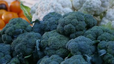 Yeşil lahana domates bir sebze pazarı heyecanlı makroda açık havada arasında yalan yığını karanlık, dotty ve küresel yüzeye sahip yeşil ve beyaz karnabahar başkanları vurdu. Bunlar pazarda domates ile sonbaharda yerleştirilir.