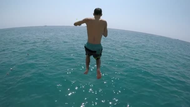 快乐的人在木码头上奔跑 先跳脚 慢动作在水上和水下拍摄一个穿着短裤的运动男子 夏天在一个木码头上跳脚 慢动作 — 图库视频影像