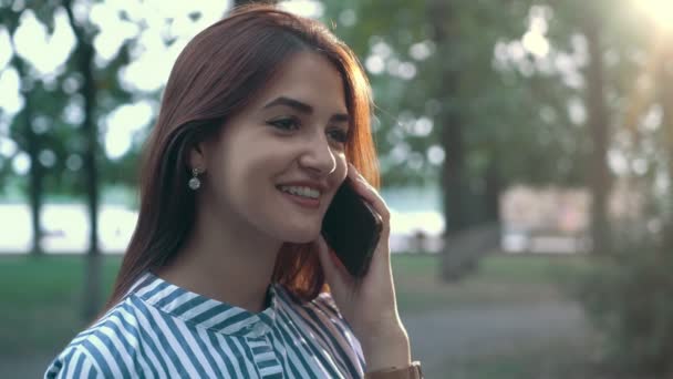 Gelukkig Meisje Glimlachend Chatten Telefoon Met Haar Vriend Een Park — Stockvideo