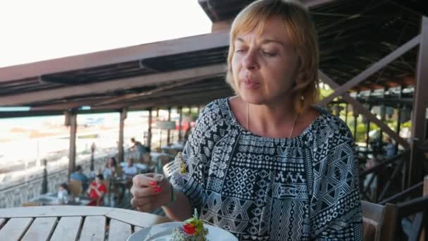 Stijlvolle Blonde Vrouw Salade Eten Een Café Zeekust Een Zonnige — Stockvideo