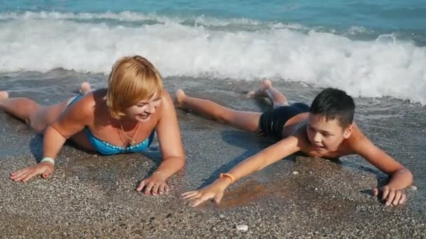 Mãe Loira Seu Filho Deitado Uma Praia Mar Jogando Alegremente — Vídeo de Stock