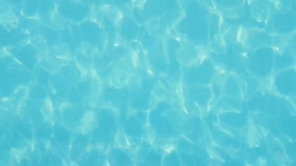 Krásný bazén s průzračnou vodou vlnící se za slunného dne v létě umělecký pohled brouzdaliště s lehce houpat celeste vody na slunečný den v létě. Hra barev vypadá optimisticky a nádherné.