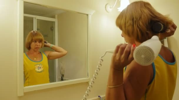 Stylish Blond Woman Brushing Fanning Her Hair Big Mirror Indoors — Stock Video