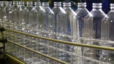 Siyah bir arka plan ile Zincirleme makara şeritlerinin boş plastik şişe siyah arka planda bir modern Zincirleme makara doğrultusunda ilerleyen etkileyici görünüm hareketli boş plastik şişe. Ruh hali ilerleme oluşturur 