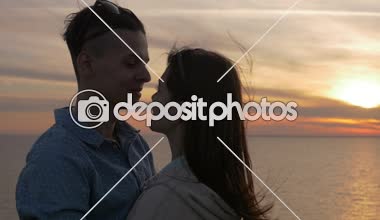 Romantik kız arkadaşı slo-mo onun güzel kız uzun bağsız kıl ile Karadeniz sahilinde yaz slo-mo renkli batımında sarılma ihale gencin iyimser profil deniz batımında öpüşme aşk genç adam