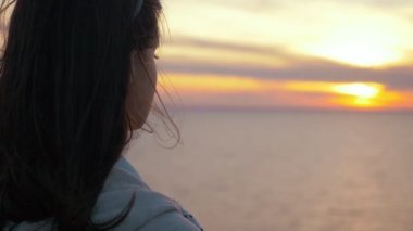 Çekici kız ağır çekimde görkemli günbatımı, çimenli deniz plajda uzun bağsız kıl ayakta ile yaz aylarında yavaş hareket geri closeup ihale genç esmer kız muhteşem gün batımı, deniz kıyısında ayakta