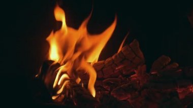 Spurts sarı ve kırmızı ateş birkaç ahşap kereste koyu şömine Magic portre spurts yavaş yavaş charcoals ve siyah bir şömine ahşap günlükleri yanan alev dans içinde oynamaya. Alev muhteşem görünüyor.
