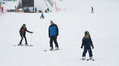 Zakopane, Polonya - 10 Aralık 2018: iyimser görünümü slo-mo aralarında sürgülü pro bir adam ve iki çocuk aşağı kayak