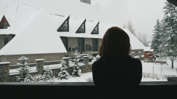 Nadenkend Vrouw Kijkt Van Vallende Sneeuw Een Terras Een Berghotel — Stockvideo