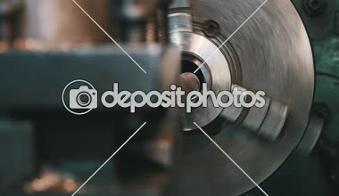 Metal çubuk dönen bir torna makine üzerinde büyük atölye metalik pul bitki üzerinde kesmek için bir torna delik makinesi yaklaşan bir metal çubuk etkileyici manzara içinde hareket ediyor