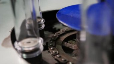 Bitki uzun transparan ampuller bir yağ fabrikası zincirli konveyör sürme Closeup üreten bir yağ bir konveyör satırda hareket uzun cam şişeler