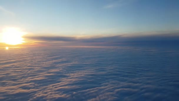 輝く紫と青の雲を見て山雪のように輝く夕焼けセレステ空飛ぶ航空機からのサンセット豪華な概観図ビューで航空機から見て青と紫の雲の空中ショット — ストック動画