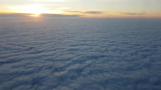 夏に飛行機の窓から輝く梁と驚異的な夕暮れ時荒れた海のように青い雲の下を飛んでの夏見事な鳥の目のビューで素敵な夕日で飛行機の窓からの青い雲の空中ショット — ストック動画