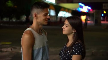 Neşeli adam ve şehirde yaz harika manzara brunet yakışıklı bir gri bir-gömlek ve şık bir kız gece ile sohbet ve yaz aylarında bir sokakta gülümseyen uzun bağsız kıl sokak konuşurken gülümseyen kız