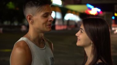 Mutlu adam ve gülümseyen kız zarif uzun saçlı konuşuyor ve yaz aylarında bir sokakta gülümseyen City yaz neşeli görünümünde bir gri bir-gömlek ve güzel bir kız bir sportif brunet erkekte ve geceleri sokak sohbet arkadaşı