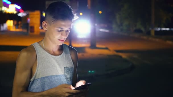 Joven Pensativo Navegando Por Red Dispositivo Una Ciudad Por Noche — Vídeos de Stock
