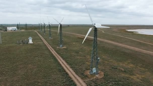 夏に灰色のスカイラインと黒海沿岸の田舎道に沿って置かれるファンの回転といくつかの風エネルギーのコンバーターのニコラエフ ウクライナ 2018 バード ビュー — ストック動画