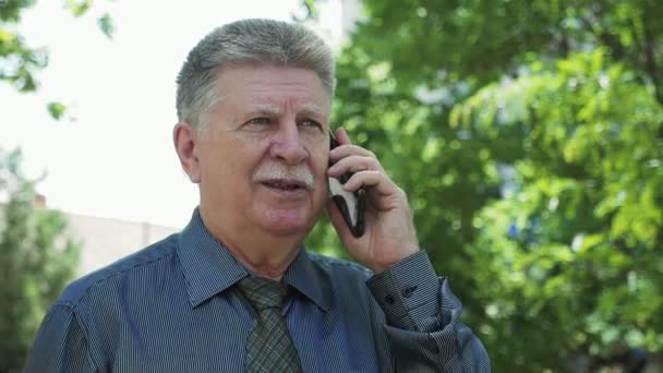 Homme Âgé Confiant Bavardant Sur Son Téléphone Dans Parc Verdoyant — Video