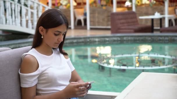 Mulher Encantadora Digitando Mensagens Seu Telefone Café Uma Lagoa Celeste — Vídeo de Stock