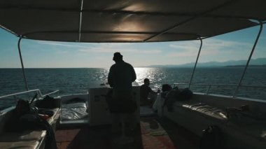 Sharm el Sheikh, Mısır - October24, 2018: arkadan görünüm görkemli günbatımı slo-mo Mısır'daki altın güneş yolu ile bir büyük turistik motorboard geminin tekerlek iterek deneyimli bir dümenci